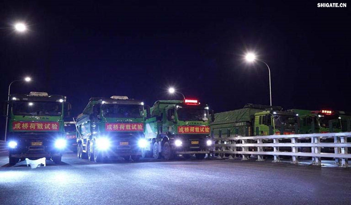 6月16日22時(shí)，世界最大跨度斜拉橋——常泰長(zhǎng)江大橋燈火通明，車聲轟鳴，一場(chǎng)通車前的“極限挑戰(zhàn)”正緊張進(jìn)行。30輛總重達(dá)1200噸的四軸加載車，分批列隊(duì)駛上橋面預(yù)先劃定的停靠點(diǎn)，并由提前布置在橋梁各關(guān)鍵部位的869個(gè)傳感器開展實(shí)時(shí)監(jiān)測(cè)，采集測(cè)試數(shù)據(jù)。由此，大橋跨江公鐵合建段主橋橋梁荷載試驗(yàn)全面啟動(dòng)。    AA1GQ79M.jpg    這次荷載試驗(yàn)覆蓋范圍具體包括1座主跨1208米斜拉橋、2座主跨388米鋼桁拱專用航道橋、1座非通航道孔橋以及南北兩座引橋，共設(shè)計(jì)119個(gè)靜載工況和111個(gè)動(dòng)載工況。其中，最大對(duì)稱靜力加載工況將動(dòng)用110輛四軸加載車，總重達(dá)4400噸。試驗(yàn)將持續(xù)一周，分五個(gè)階段進(jìn)行。試驗(yàn)首日在錄安洲非通航孔橋和常州側(cè)公鐵合建段引橋?qū)嵤? 常泰長(zhǎng)江大橋是連通常州與泰興的跨江通道，是長(zhǎng)江上首座集高速公路、城際鐵路和普通公路三種功能于一體的雙層復(fù)合型橋梁，計(jì)劃于今年年內(nèi)基本建成。它的上層為雙向六車道高速公路，下層為雙線城際鐵路和普通公路。如此復(fù)雜的結(jié)構(gòu)，如何確保它在未來(lái)百年服役中安全可靠？答案就藏在荷載試驗(yàn)中。    AA1GQduQ.jpg    荷載試驗(yàn)堪稱橋梁通車前的“綜合大考”，是確保橋梁安全運(yùn)營(yíng)的“體檢報(bào)告”。江蘇省交通工程建設(shè)局常泰長(zhǎng)江大橋建設(shè)指揮部現(xiàn)場(chǎng)常務(wù)副指揮長(zhǎng)夏鵬飛介紹，“荷載試驗(yàn)是檢測(cè)橋梁結(jié)構(gòu)安全和承載能力的重要手段，通過(guò)科學(xué)的加載測(cè)試和數(shù)據(jù)采集分析，驗(yàn)證實(shí)際成橋狀態(tài)與理論設(shè)計(jì)的鍥合度，確保常泰長(zhǎng)江大橋運(yùn)營(yíng)安全。”考慮到大橋主體采用鋼結(jié)構(gòu)和鋼-混凝土組合結(jié)構(gòu)，為最大限度減少晝夜溫差對(duì)測(cè)試數(shù)據(jù)的影響，所有試驗(yàn)均安排在夜間實(shí)施。  通過(guò)一系列科學(xué)嚴(yán)謹(jǐn)?shù)暮奢d測(cè)試，這座世界級(jí)多功能大橋的實(shí)際性能將得到充分檢驗(yàn)，為常泰長(zhǎng)江大橋后續(xù)安全通車運(yùn)營(yíng)提供至關(guān)重要的數(shù)據(jù)支撐。
